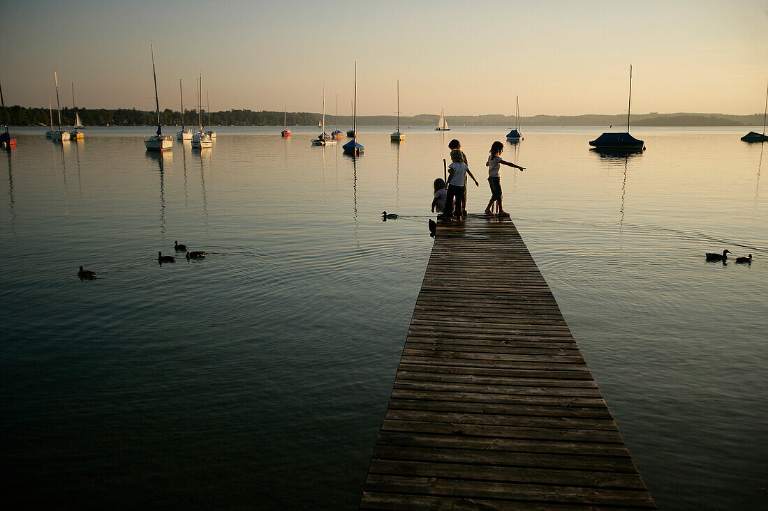 Kinder stehen auf einem Holzsteg am Wörthsee, Bayern, Deutschland, MR