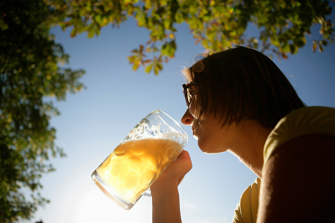 Frau mittleren Alters trinkt Bier, Biergarten vom Restaurant Woerl, Wörthsee, Bayern, Deutschland, MR