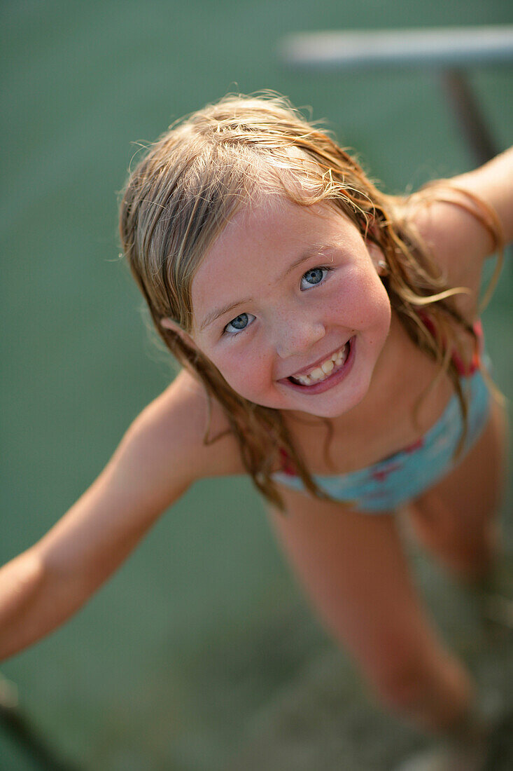 Girl coming out of Lake Woerthsee and smiling at camera, Walchstadt, Bavaria, Germany, MR