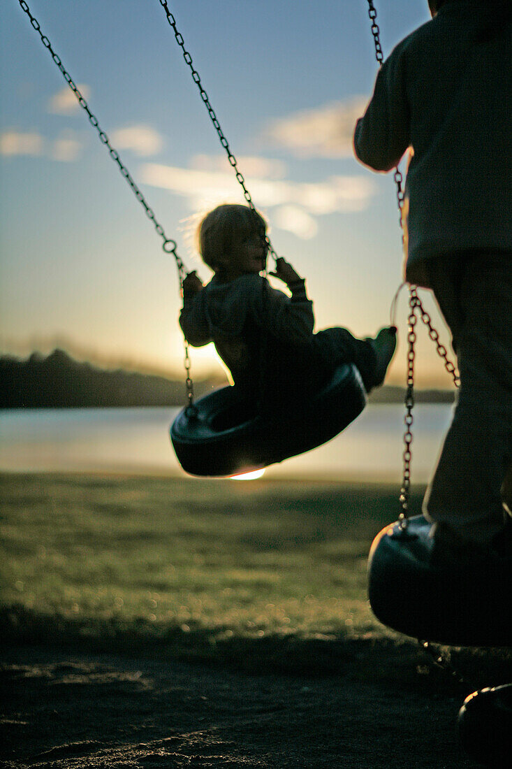 Children on a swing near the lakeshore, Madkroken, Smaland, Sweden