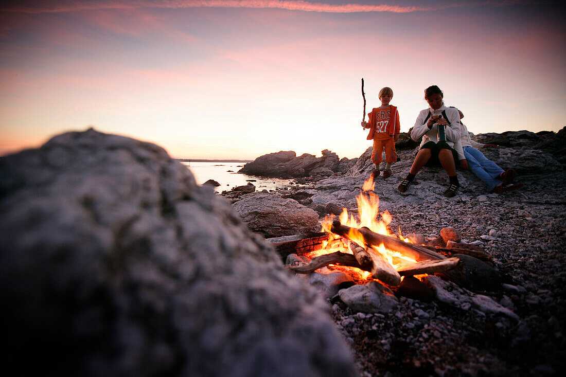 Mutter und zwei Kinder am Strand, Lagerfeuer, Sonnenuntergang, Sysne, Gotland, Schweden