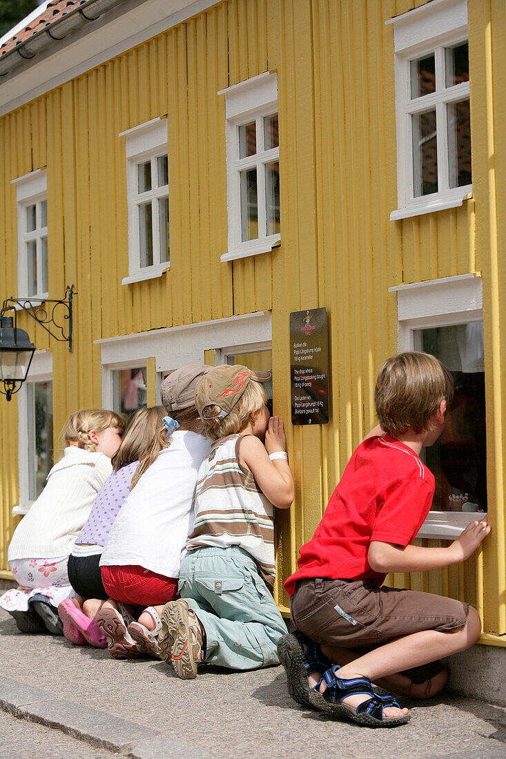 Kinder schauen eine Szene aus Pippi Langstrumpf an, in einem Miniaturhaus, Astrid Lindgren's Welt, Vimmerby, Smaland, Schweden