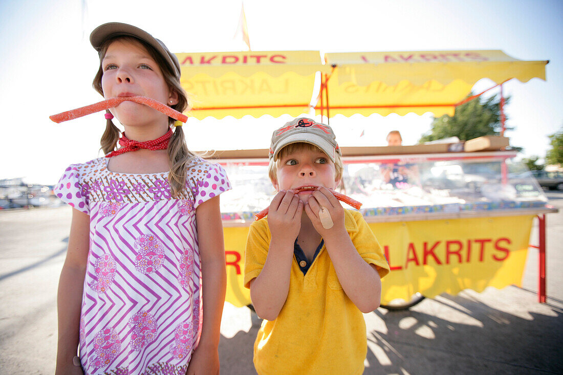 Boy and girl eating candy, typical liquorice, Visby, Gotland, Sweden