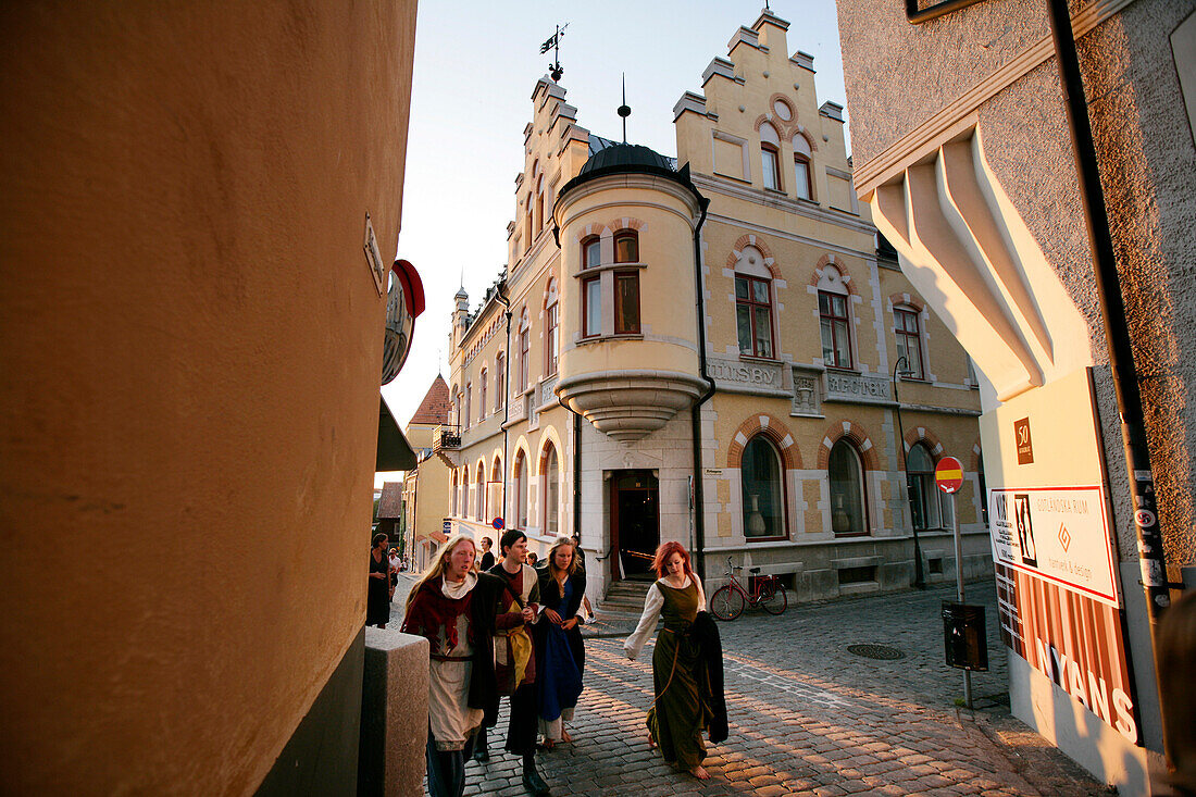 People, pedestrians walking down the street in fancy dress during medievel week, old town, Visby, Gotland, Sweden