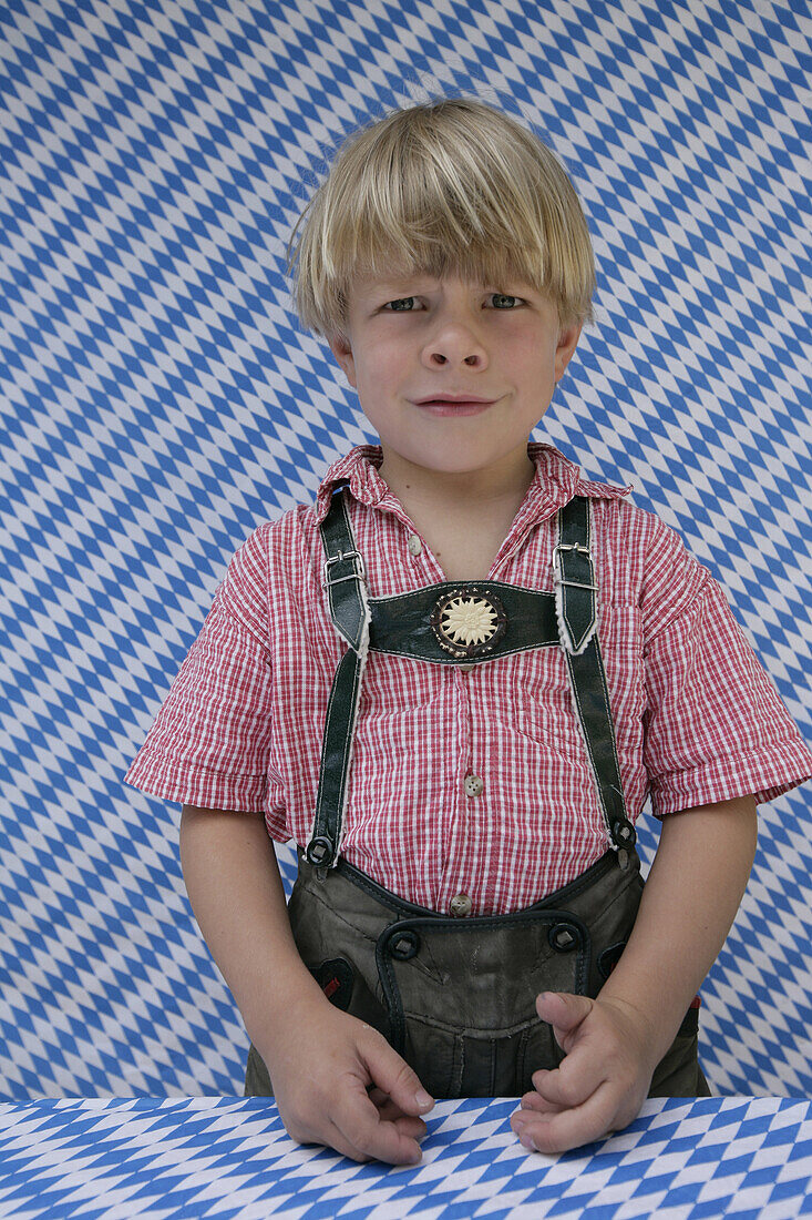 Trauriger Junge (4-5 Jarhe) in Lederhosen blickt in die Kamera, Münsing, Oberbayern, Bayern, Deutschland