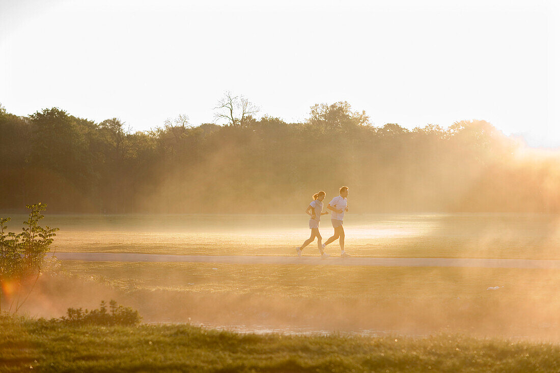 Paar joggt im Englischen Garten am Morgen, München, Oberbayern, Bayern, Deutschland
