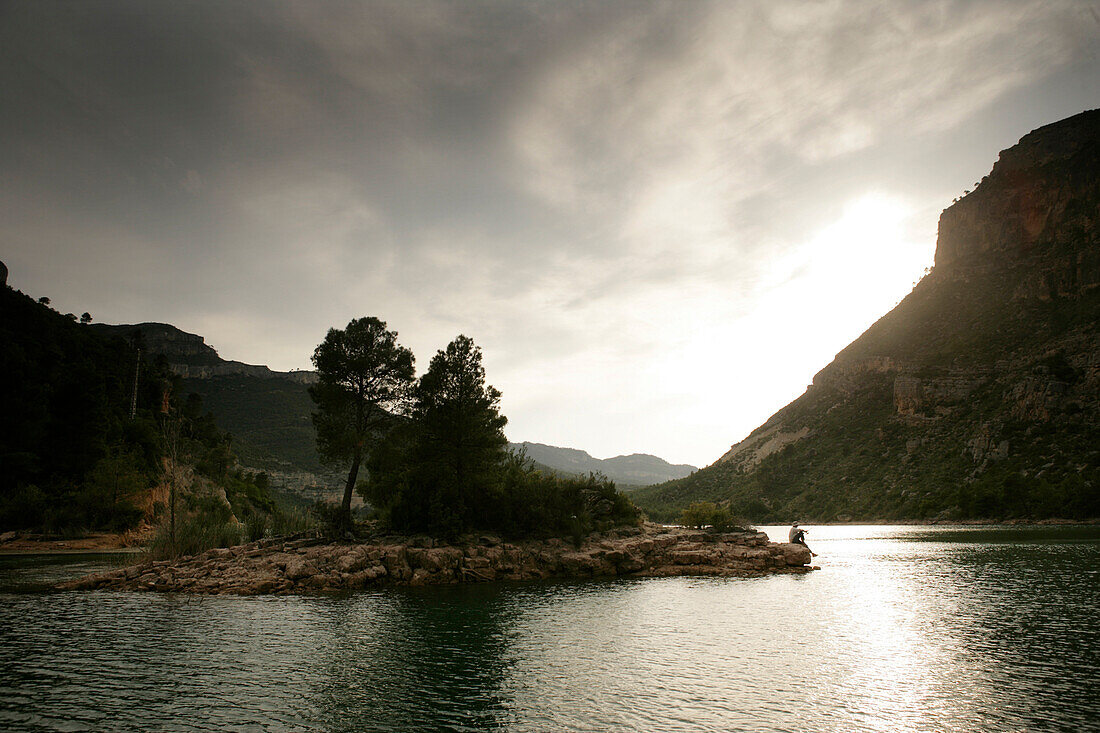 Man fishing on a small island at a reservoir, lake, Valencia region, Spain