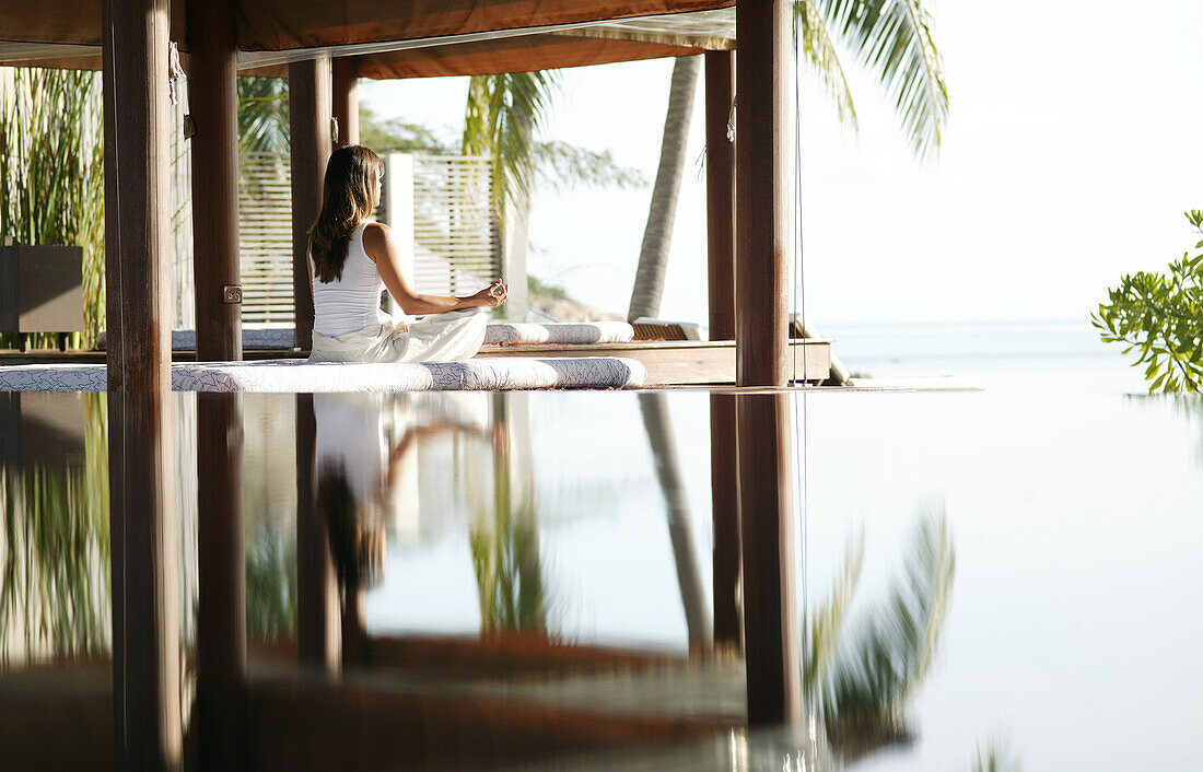 Frau beim Meditieren, Spiegelung im Wasser, Entspannung, Gesundheit, Wellness