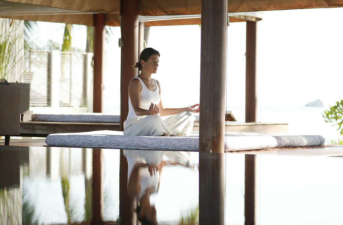 Frau beim Meditieren, Spiegelung im Wasser, Wellness, Gesundheit, Entspannung