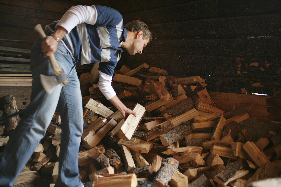 Man chopping wood on alp, Heiligenblut, Hohe Tauern National Park, Carinthia, Austria