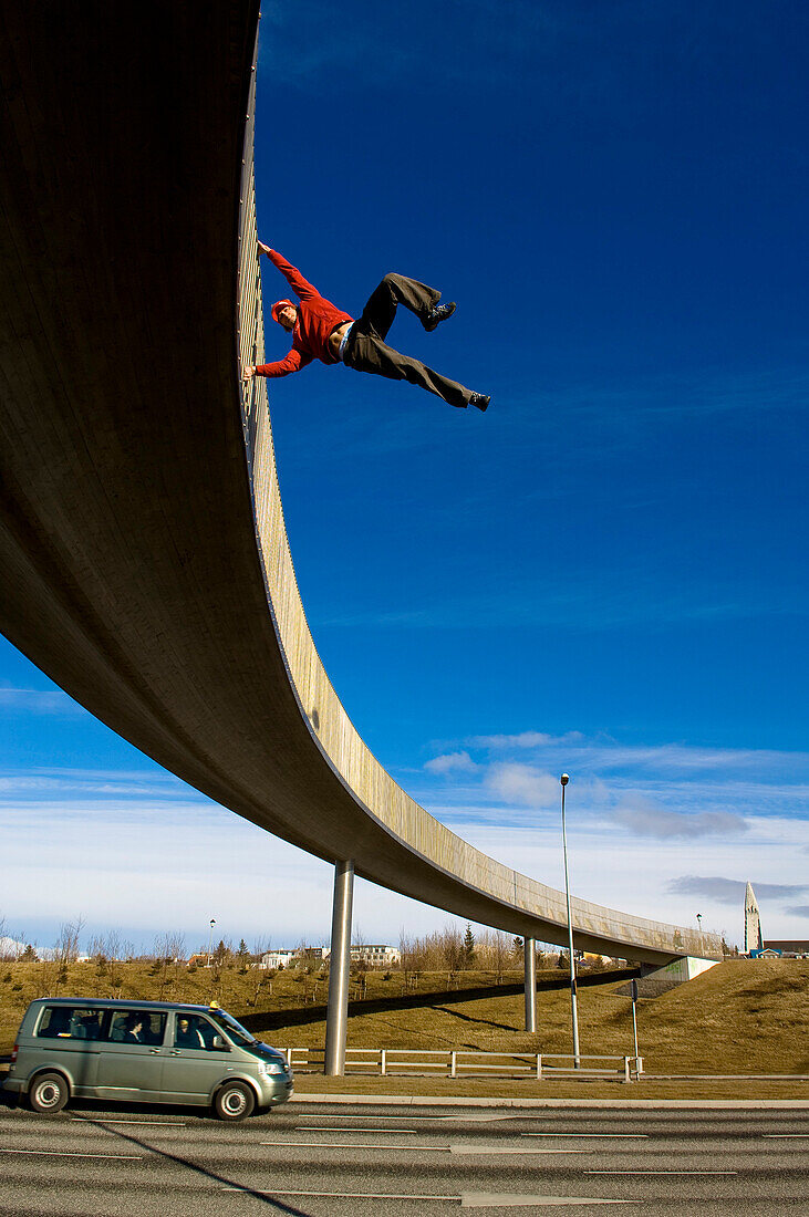 Man freeclimbing on bridge, Reykjavik, Iceland