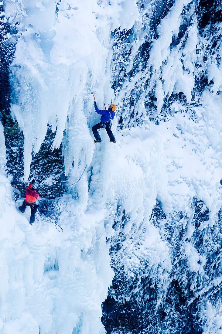 Ice climber in frozen waterfall, Iceland