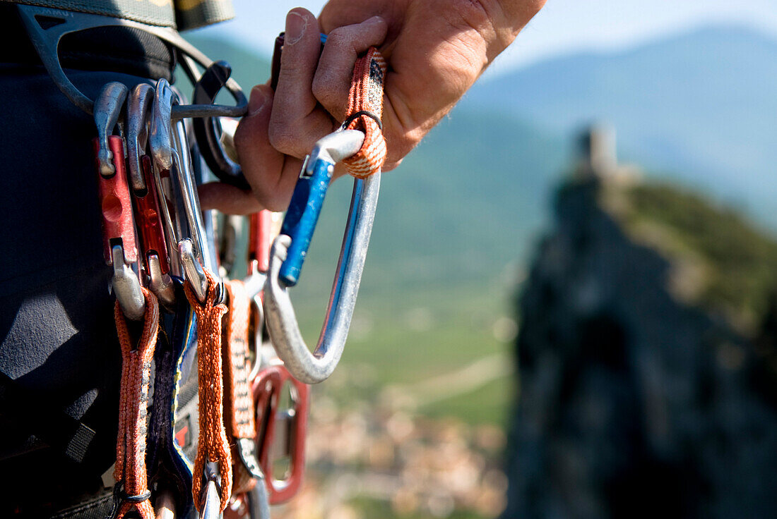 Kletterer hält einen Karabiner, Arco, Trentino-Südtirol, Italien