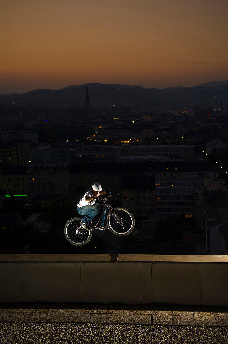 Trialbiker on edge of Highrise, Linz, Austria