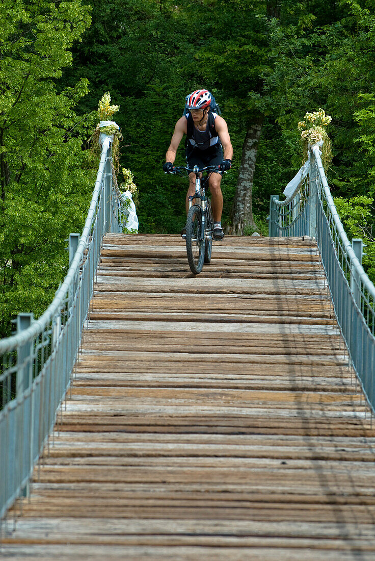 Mountainbiker on suspension bridge, Slovenia