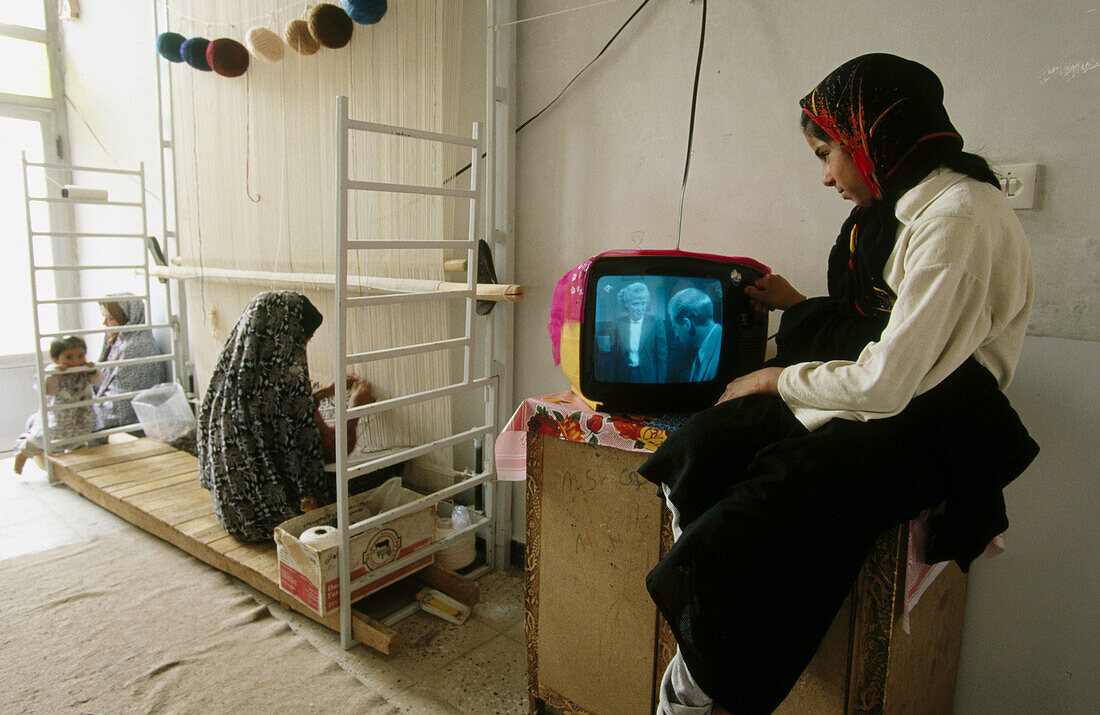 Persian woman weaving carpet. Nain. Iran.