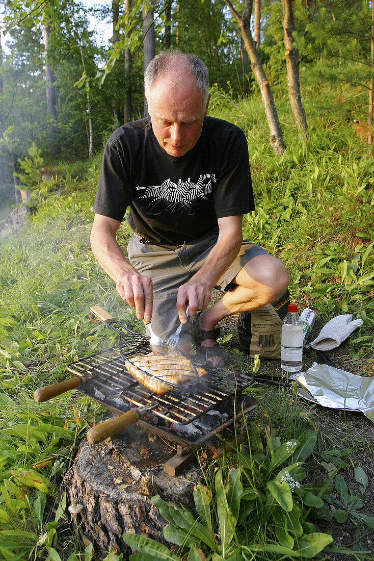 Putting salmon on the grill. Sweden
