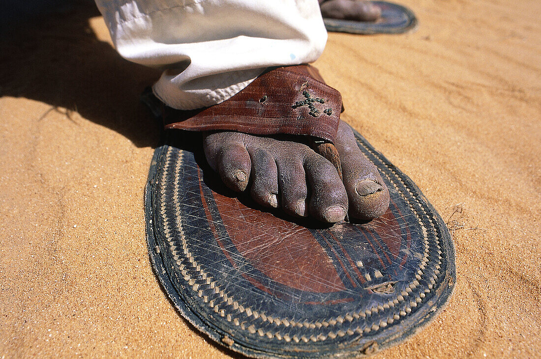 Detail of tuareg wearing large sandals for easier walking on sand. Djanet oasis, Sahara desert. Algeria