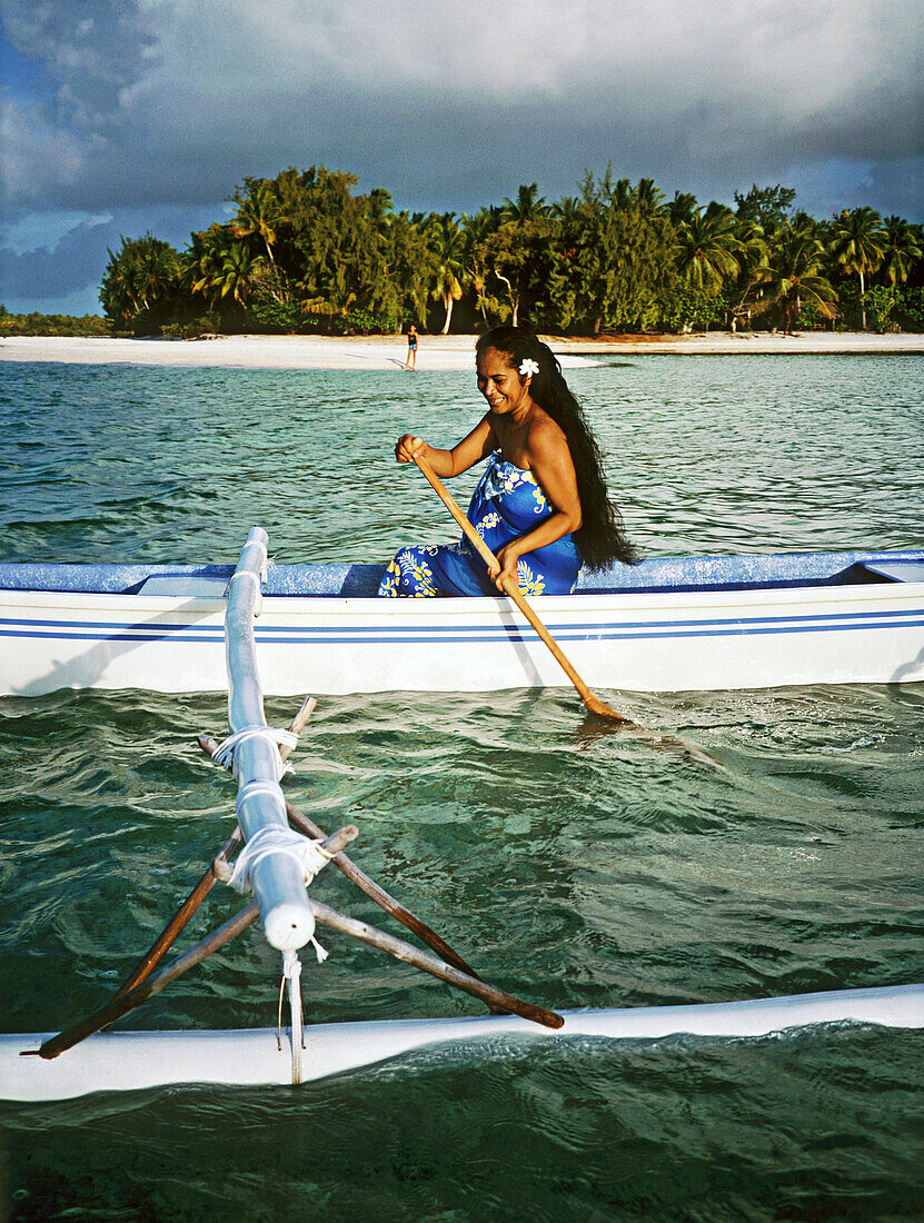 Woman paddling on her outrigger. Rangiroa atoll. Tuamotu archipelago. French Polynesia