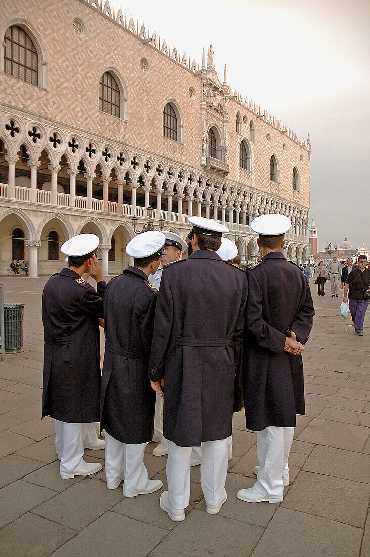 Navy officers talking on San Marco piazza (square)by the doges palace. Venice. Italy