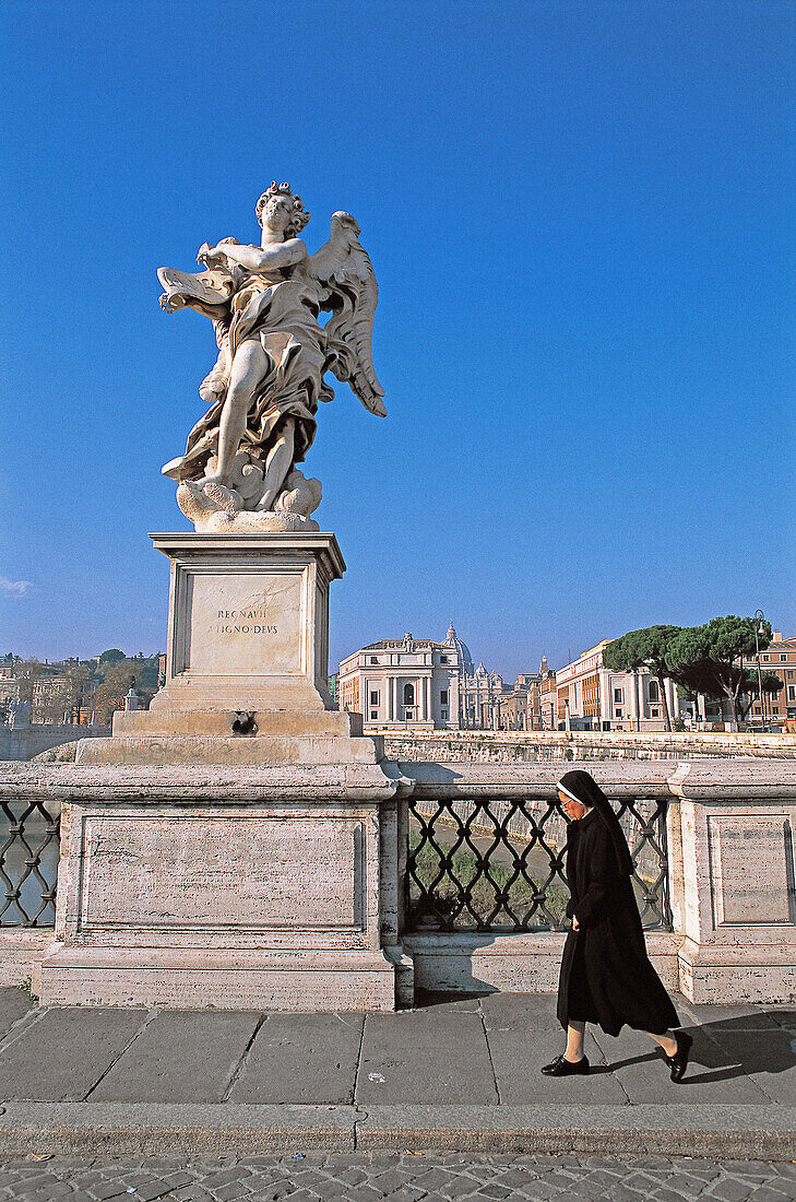 Nun passing by statue of angel at Sant Angelo bridge. Vatican City, Rome. Italy