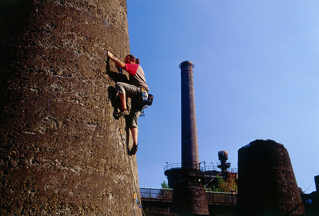 Climber climbing up a tower at Hütte Meiderich, Public Park in Duisburg North, Duisburg, Ruhr Valley, North Rhine Westphalia, Germany