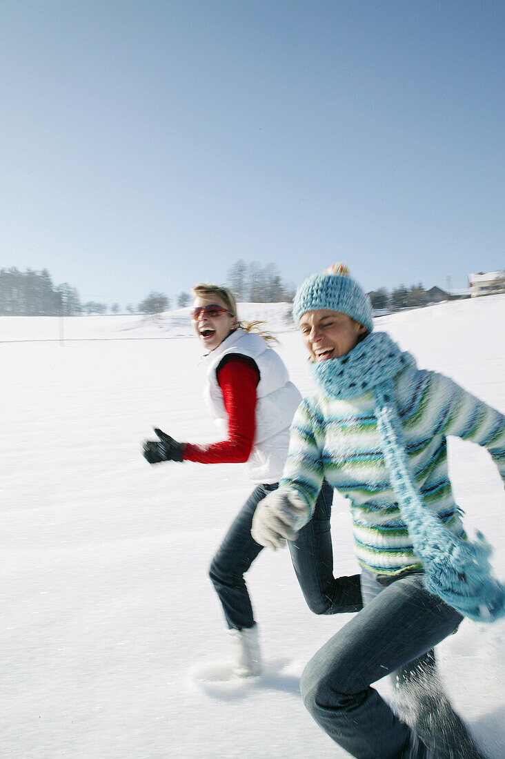 Zwei Frauen laufen nebeneinander durch den Schnee, Steiermark, Österreich