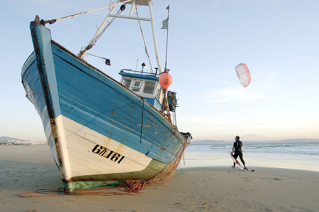  Aussen, Außen, Boot, Boote, Eine Person, Eins, Erwachsene, Erwachsener, Farbe, Fehl am Platze, Fischerboot, Fischerboote, Freizeit, Gehen, Gehend, Gehende, Horizontal, Küste, Mann, Männer, Männer (nur), Männlich, Meer, Mensch, Menschen, Strand, Strände, 