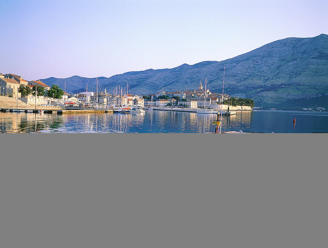 Fishing boat and the fortified city in background. Korcula Island. Croatia