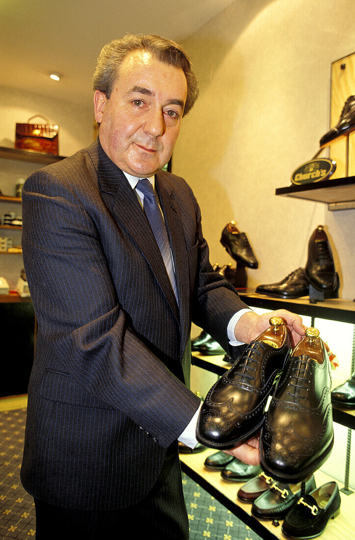 Mr. Brian Jones showing Church s men shoes in his shop. London. England