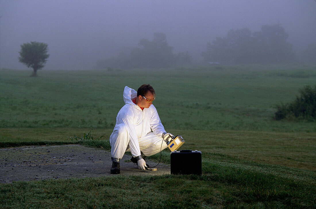 Worker taking Geiger counter readings around nuclear clean-up site