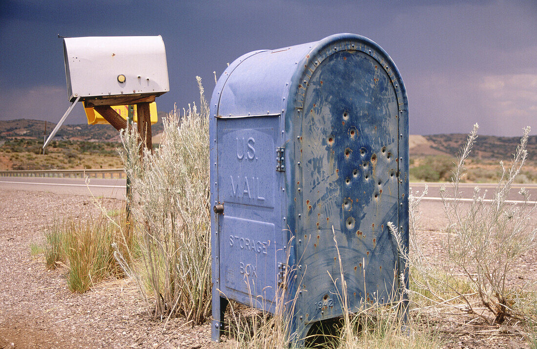 USA, New Mexico, Silver City. US mail box riddled with bullet holes beside route 90, south of Silver City.