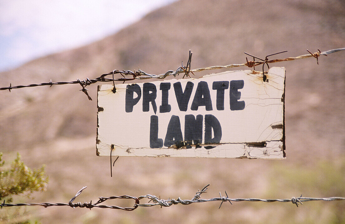 USA, New Mexico, Lordsburg. Private property sign on barbed wire fence at granite gap.