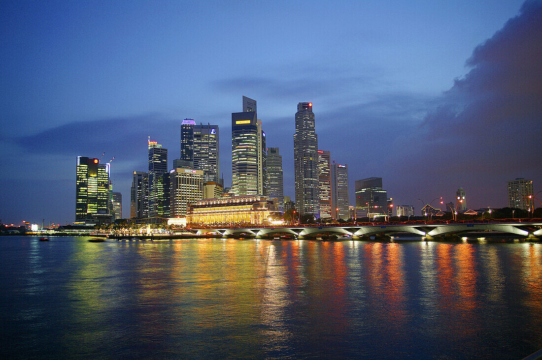 Night view of the Singapore skyline from Marina Bay, with Esplanade Bridge, Fullerton Hotel and Merlion. Singapore.