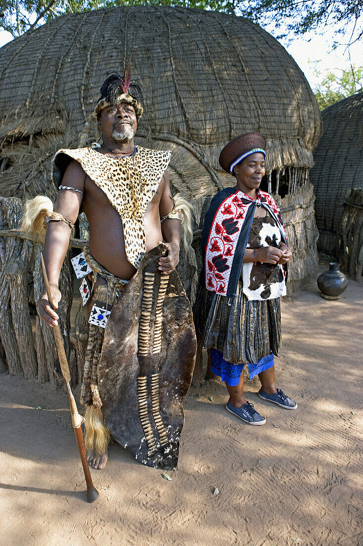 The Chief Biyela dressed with his ceremonial leopard skin and his third wife. Simunye zulu village where visitors can be accomodated in zulu style. Kwazulu-Natal province. South Africa