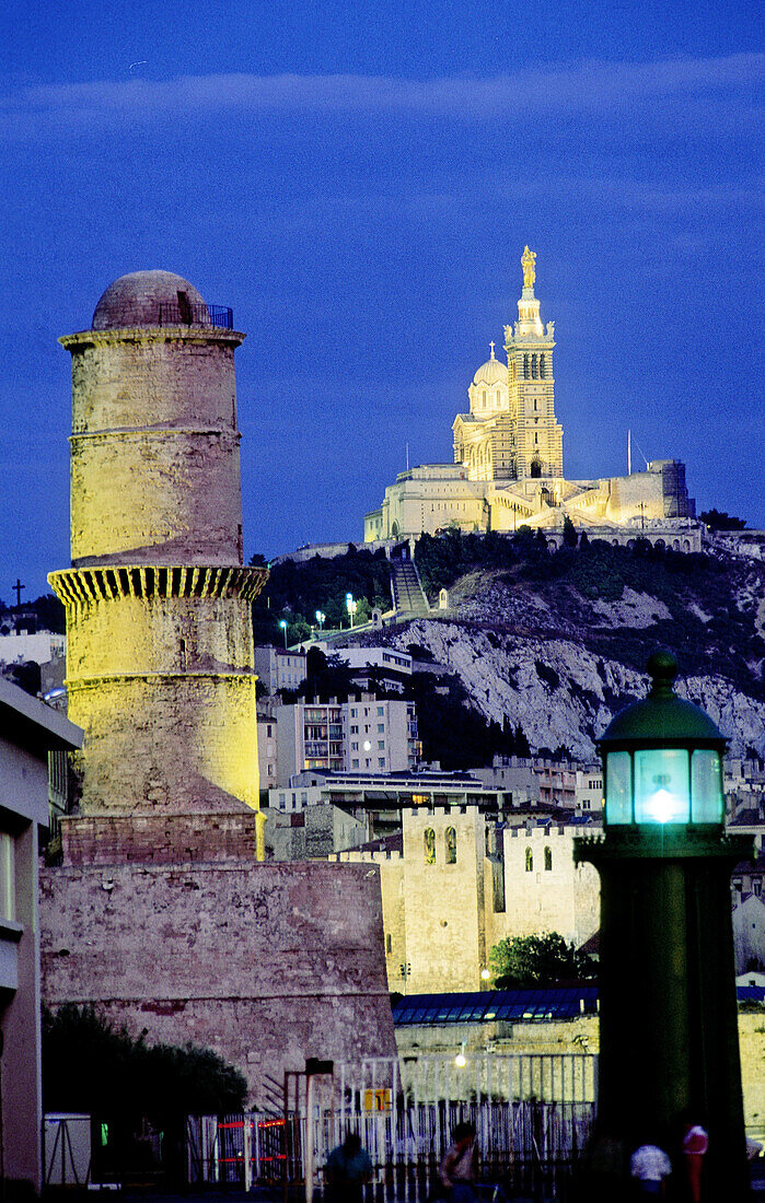 Harbour at night, church of Notre Dame de la Garde on the top of the hill, Marseille. Bouches-du-Rhône, France