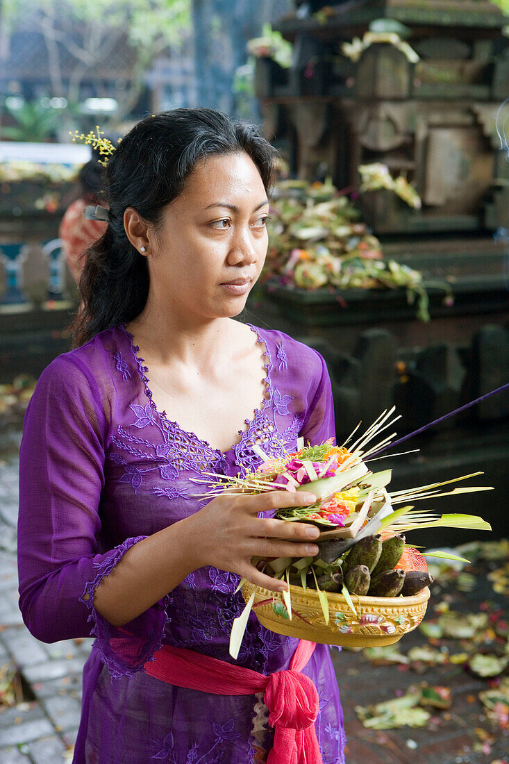 Woman making offerings in a temple. Ubud. Island of Bali . Indonesia
