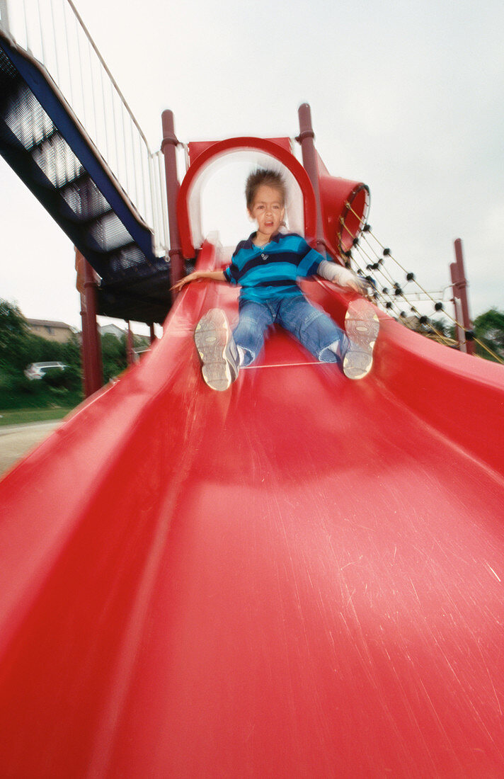 Boy on red sliding board
