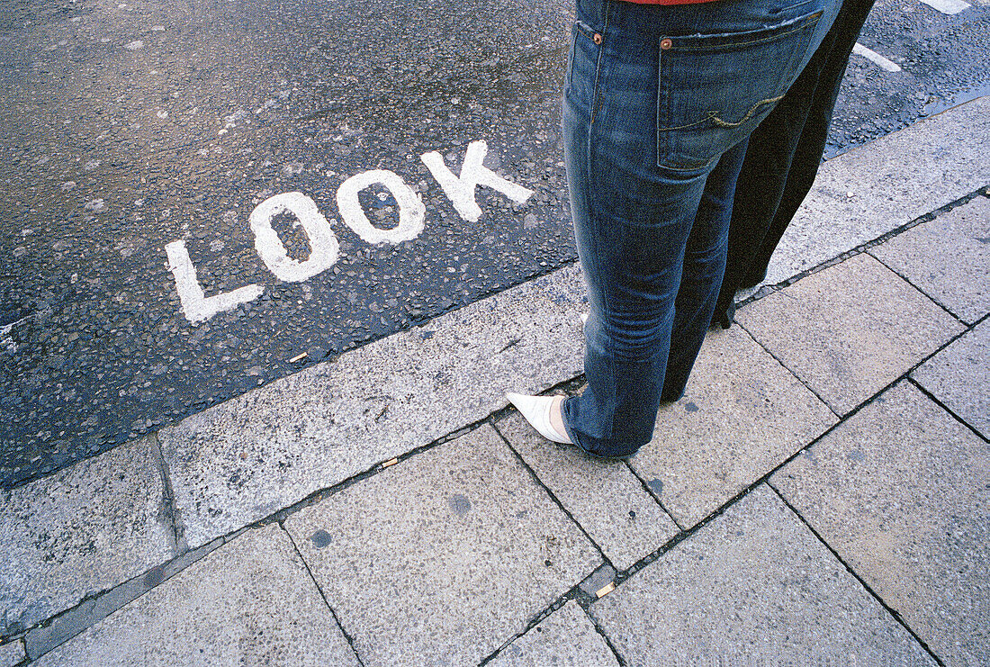  Adult, Adults, Anonymous, Asphalt, Blue jean, Blue jeans, Caution, Cities, City, Color, Colour, Curb, Curbs, Daytime, Denim, Europe, Exterior, Female, Great Britain, Horizontal, Human, Jean, Jeans, Kerb, Kerbs, Leg, Legs, Motionless, One, One person, Out