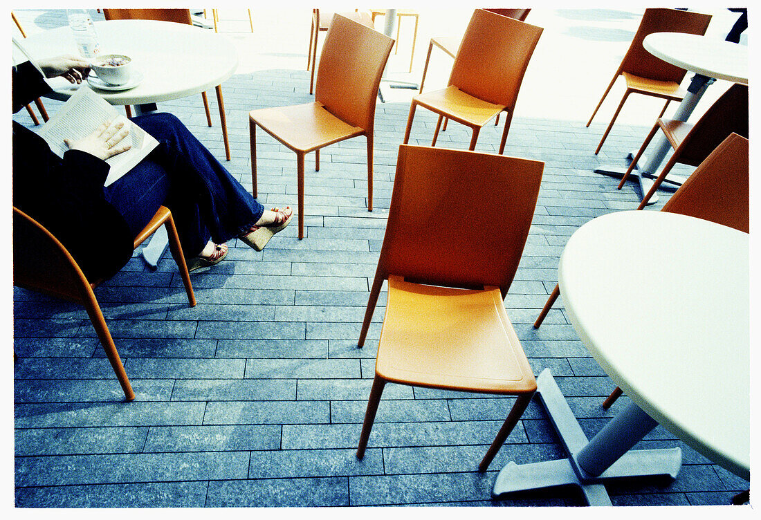  Adult, Adults, Alone, Anonymous, Book, Books, Cafe terrace, Cafe terraces, Calm, Calmness, Chair, Chairs, Coffee, Color, Colour, Contemporary, Crossing legs, Daytime, Exterior, Female, Horizontal, Human, Legs crossed, Leisure, One, One person, Outdoor, O