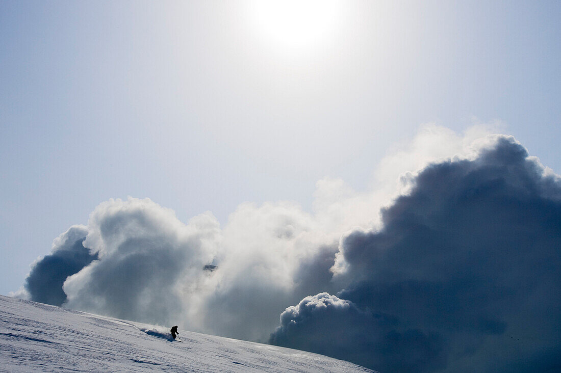 Heliskiing am Vulkan Zhupanovsky, Jupanovsky Kamtschatka, Sibirien, ein Mann fährt mit Skis im Tiefschnee