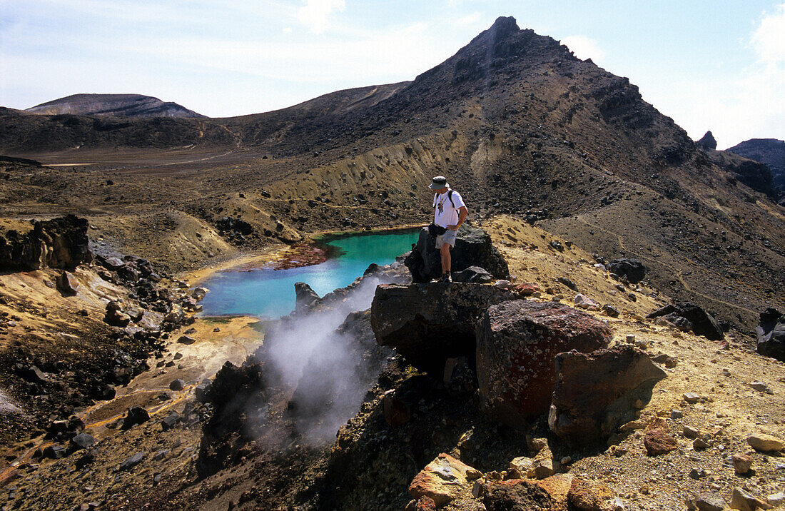 Tourist looking at fomarole at Emerald Lakes, Tongariro Crossing, Tongariro National Park, North Island, New Zealand