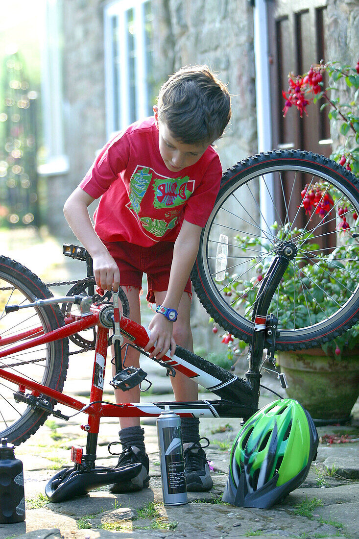  Child, Childhood, Children, Color, Colour, Contemporary, Cycle, Cycles, Dark-haired, Daytime, Exterior, Fixing, Focus, Focused, Full-body, Full-length, Headgear, Helmet, Helmets, Human, Infantile, K