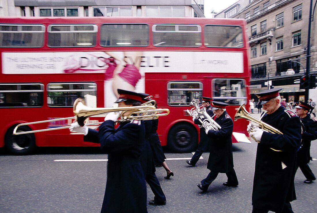 The Salvation Army band passing by bus with sexy ad. London. England
