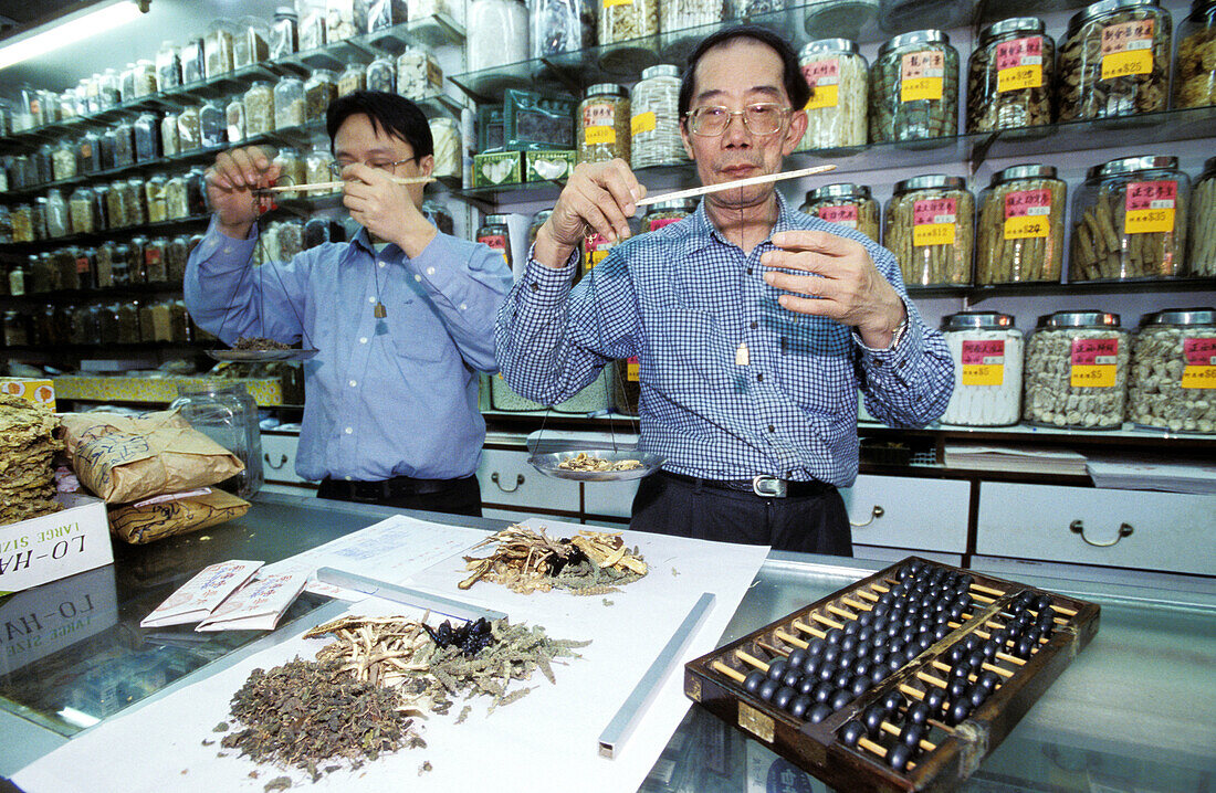 Traditional Herbalists at work in their shop. Wanchai. Hong Kong. China