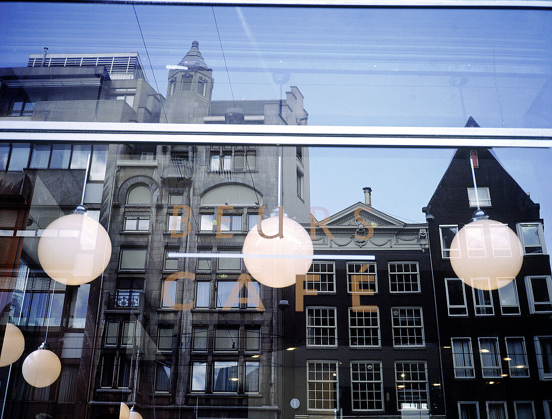 Old Flemish houses reflected on window of coffee shop. Amsterdam. Holland