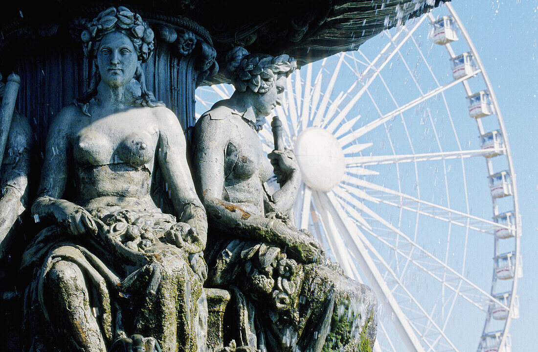Statues of Place de la Concorde fountain and big wheel in background. Paris. France