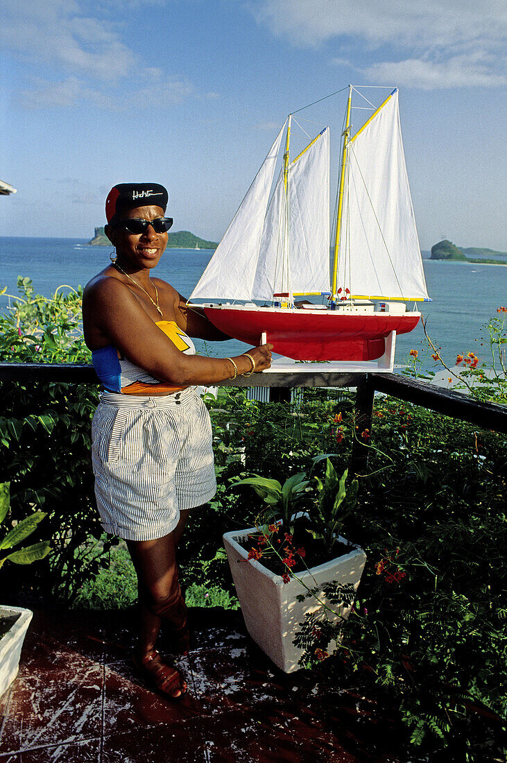 Woman making and selling scale models of ships. Carriacou Island. Grenada. Caribbean