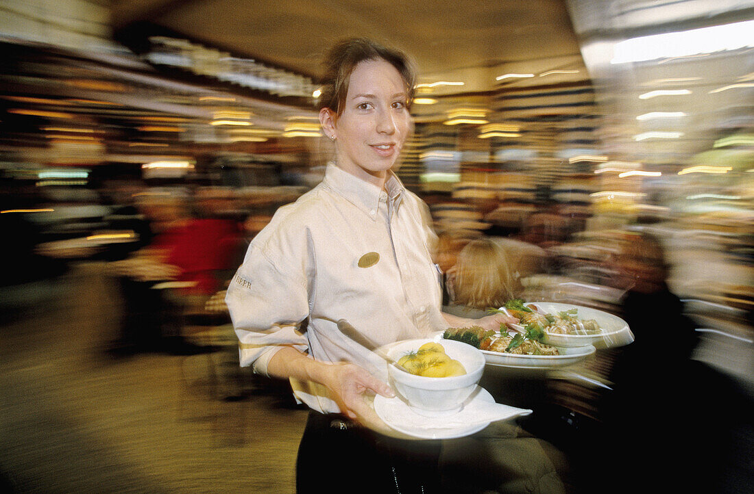 Restaurant waitress in the indoor Saluhalle Östermalm. Stockholm. Sweden