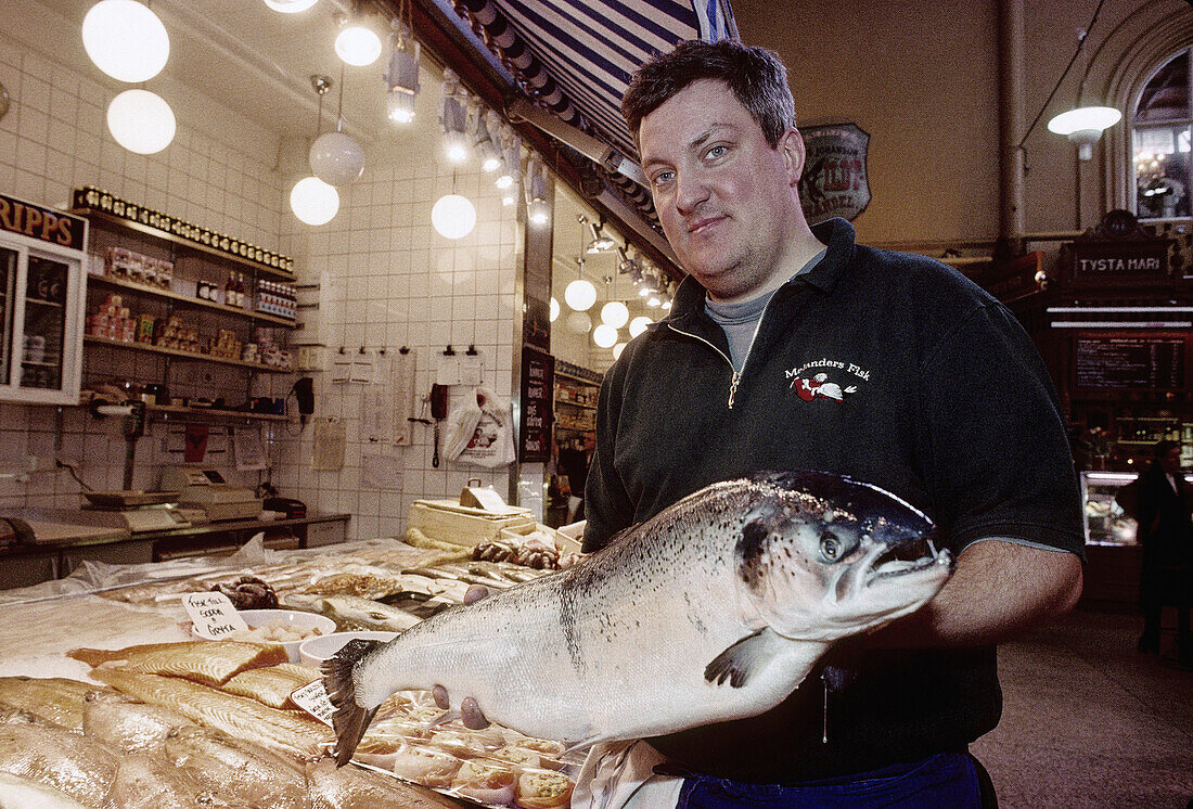 Östermalm indoor market. Fishmonger and his wild salmon best catch of the day. Stockholm. Sweden